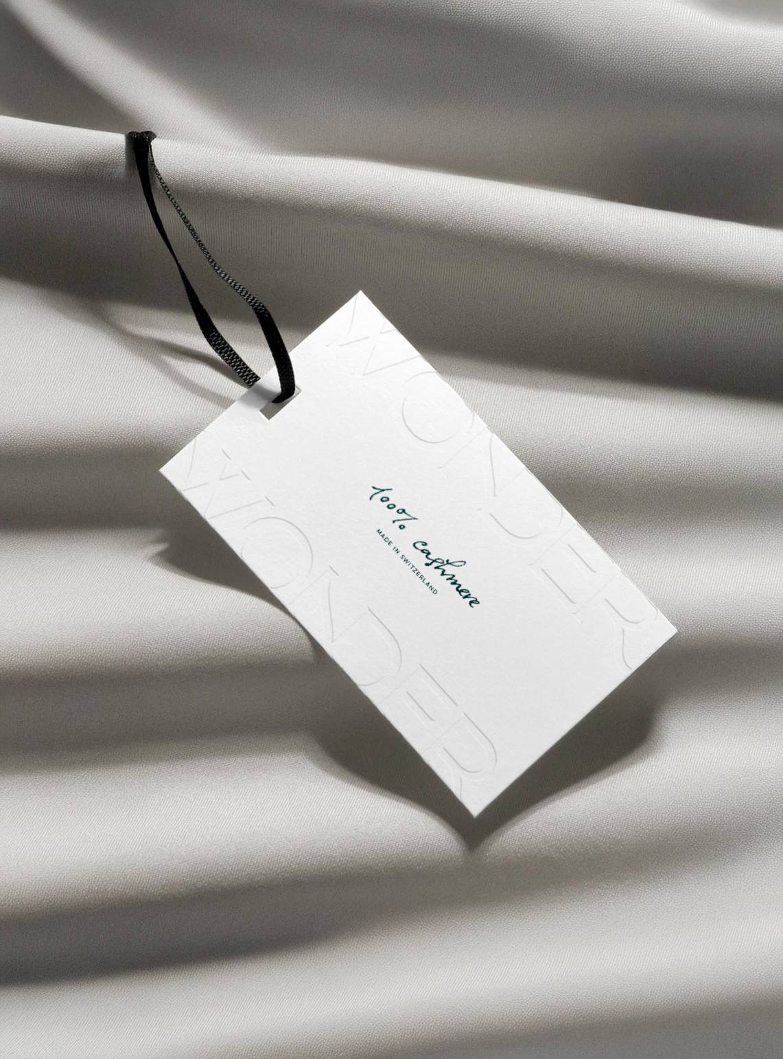 Étiquette en papier embossé « 100 % cashmere » sur tissu gris